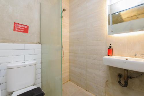 bagno con servizi igienici e lavandino di Urbanview Caverna Gandaria by RedDoorz a Giacarta