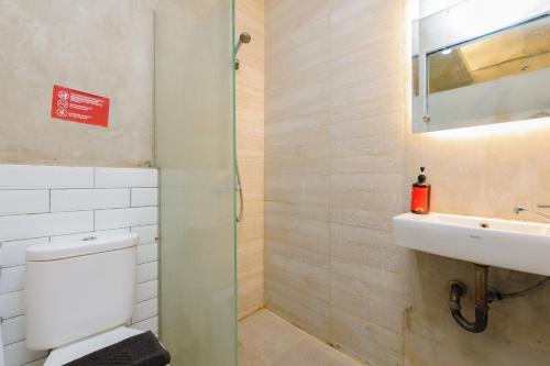 a bathroom with a toilet and a sink at Sans Stay Caverna Gandaria in Jakarta