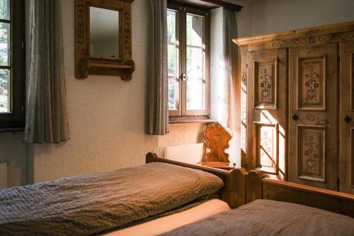 a bedroom with two beds and a mirror and windows at Mountain Lodge Ze Seewjinu - above Zermatt in Zermatt