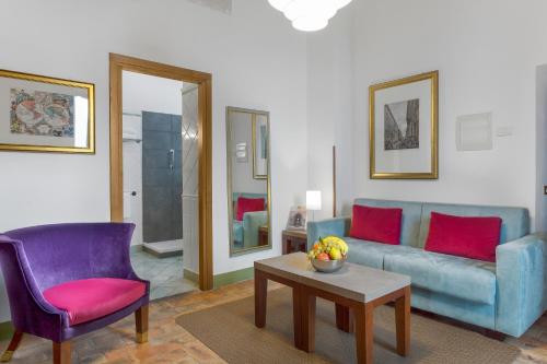 ein Wohnzimmer mit einem Sofa, 2 Stühlen und einem Tisch in der Unterkunft Palazzo Catalani Resort in Soriano nel Cimino