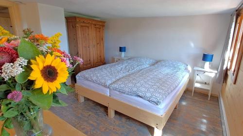 a bedroom with a bed and a vase of flowers at Ferienhaus FERGUNNA in Marienberg
