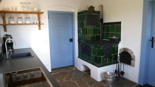 a kitchen with green tile on the wall and a stove at Ferienhaus FERGUNNA in Marienberg