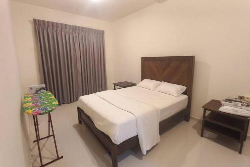 um quarto com uma cama, uma mesa e uma janela em Capital TRUST Residencies Kotte em Sri Jayewardenepur- Kotte