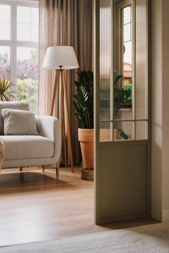 a living room with a couch and a lamp at Villa Saltic in Grzybowo