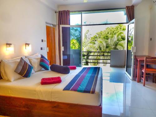 a bedroom with a large bed with a large window at The Panorama Negombo in Negombo