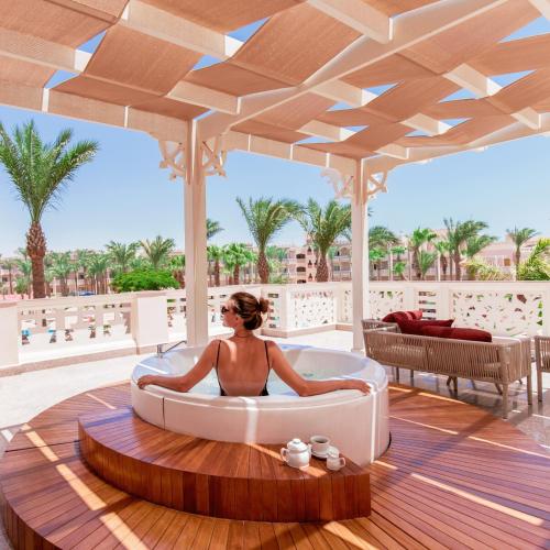 a woman sitting in a bath tub on a deck at Pickalbatros Palace - Aqua Park Hurghada in Hurghada