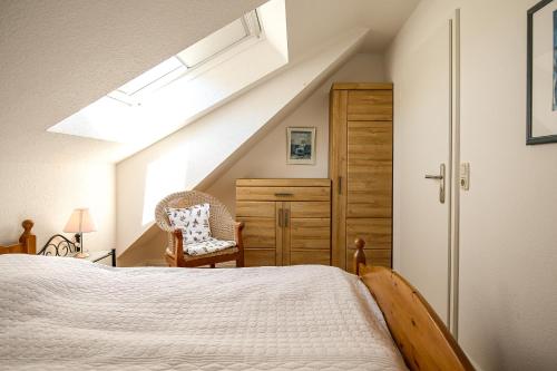 - une chambre mansardée avec un lit et une lucarne dans l'établissement Feriendorf Papillon Wohnung 10-7, à Boltenhagen