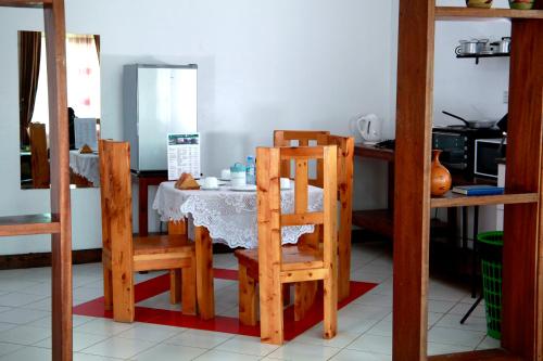 a kitchen with a table and two wooden chairs at Bunyonyi Safaris Resort in Kabale