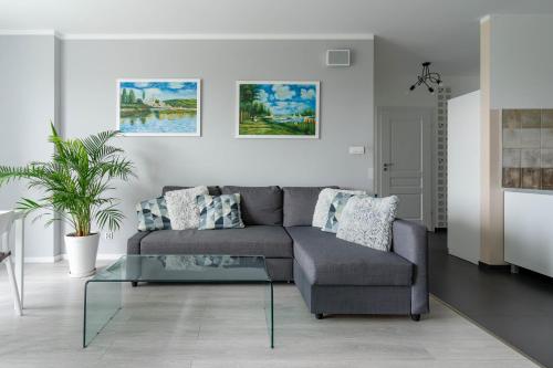 a living room with a couch and a glass table at Symphony Baltica Towers Apartamenty in Gdańsk