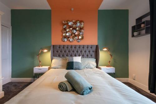 um quarto com uma cama grande com paredes em verde e laranja em Cosy home in City Centre em Lincolnshire
