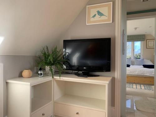 a flat screen tv sitting on top of a white entertainment center at Annexe near Malmesbury / Tetbury in Hankerton