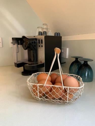 a basket of eggs in front of a coffee maker at Annexe near Malmesbury / Tetbury in Hankerton