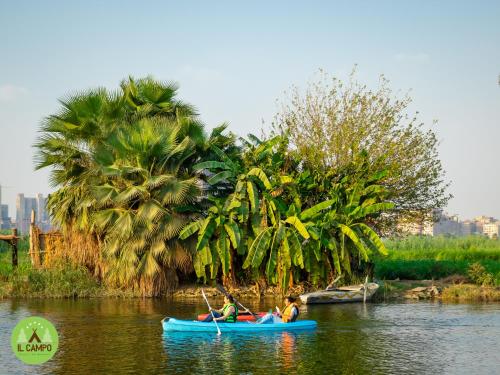 two people in a blue canoe on a river at IL CAMPO Ecolodge & Boutique Hotel in Cairo