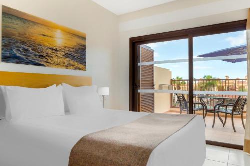 sypialnia z łóżkiem oraz balkon ze stołem w obiekcie Royal Sunset Beach Club w Adeje