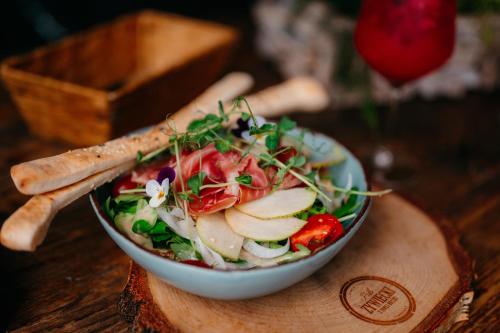 a salad in a bowl on a wooden table at SLEEP WELL 1999 in Tychy