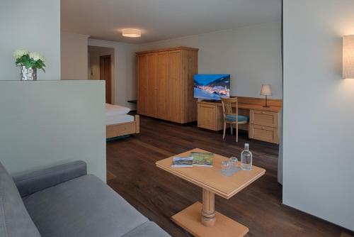 a living room with a couch and a table at Naturhotel MOLIN in San Giovanni in Val Aurina