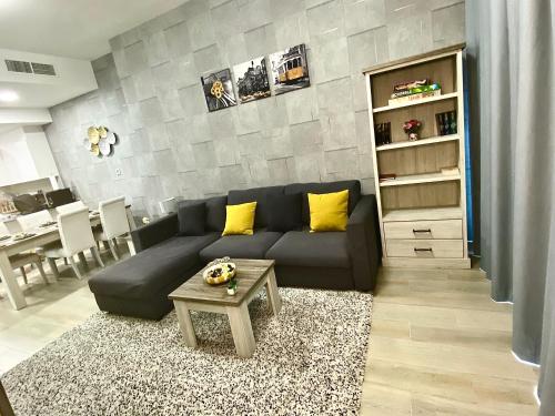 a living room with a couch and a table at Luxury 2BR for 6 with King Beds, Gym, Sauna in JVC in Dubai