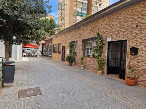 a brick alley with potted plants next to a building at APARTAMENTO ABADIA in Málaga