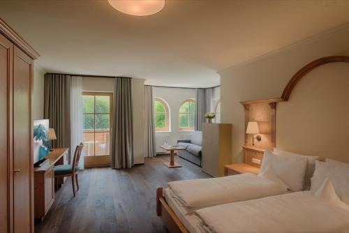 Habitación de hotel con cama y escritorio en Naturhotel MOLIN en San Giovanni in Val Aurina