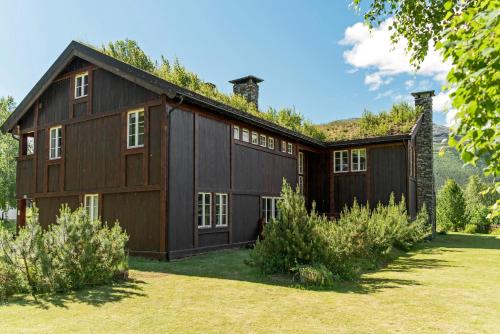 海姆瑟達爾的住宿－Villa Fredheim Farm, Hemsedal，一个带草地庭院的大型棕色谷仓