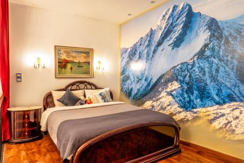 1 dormitorio con un mural de una montaña nevada en The White Rabbit Hostel, en Ban Si Than