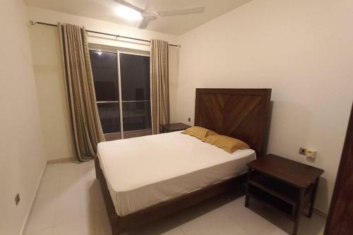um pequeno quarto com uma cama e uma janela em Capital TRUST Residencies Colombo 05 em Colombo