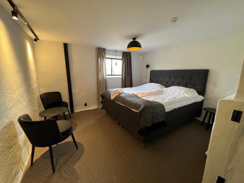 een slaapkamer met een bed en 2 stoelen. bij Backadal Gård BnB in Ystad