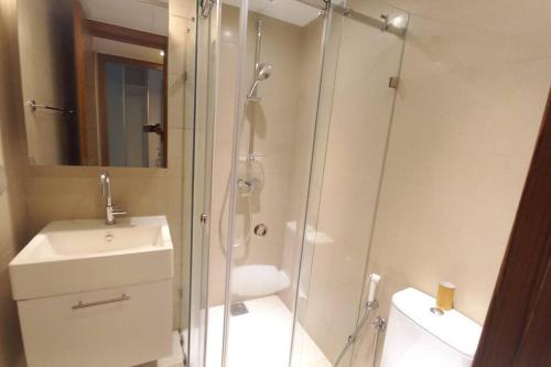 een badkamer met een douche, een wastafel en een toilet bij Havelock City Edmonton Tower Colombo 05 in Colombo