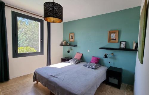 ein Schlafzimmer mit einem Bett mit zwei Kissen und einem Fenster in der Unterkunft Coste in Mollans-sur-Ouvèze