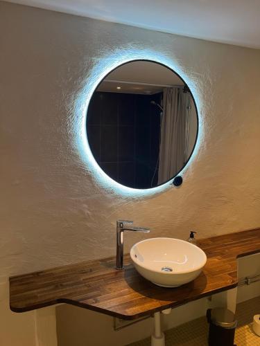 a bathroom with a sink and a mirror on the wall at Backadal Gård BnB in Ystad