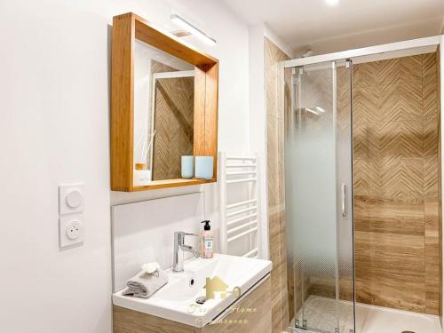 a bathroom with a sink and a shower at Les volets bleus, T2 Moderne et spacieux in Trégunc