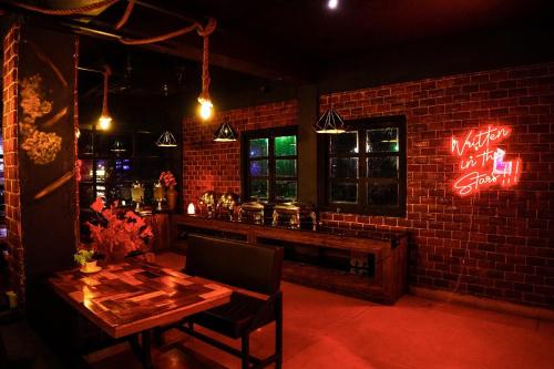 a bar with a wooden table and a brick wall at Hotel De L'amour in Port Blair