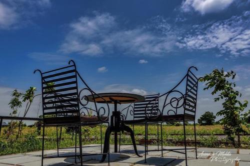 uma mesa e duas cadeiras sentadas ao lado de um campo em Jawai Greens em Jawāi Bāndh