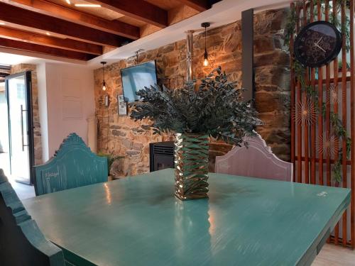 a green table with a vase of flowers on it at Ribança Village in Destriz