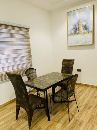 uma mesa de jantar e cadeiras num quarto em Apple Royal Apartments em Acra