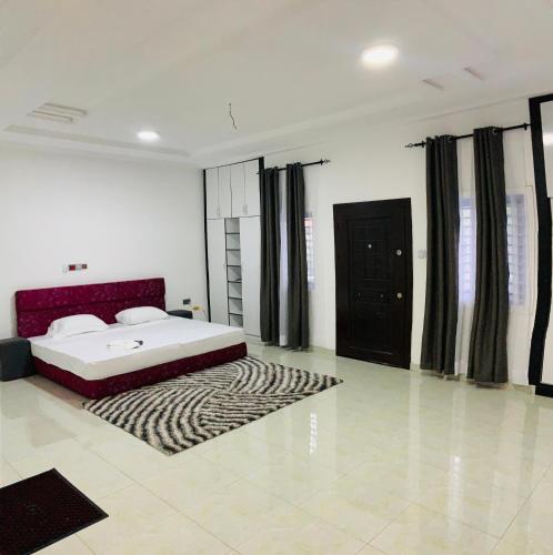 um quarto com uma cama grande e um tapete em Apple Royal Apartments em Acra
