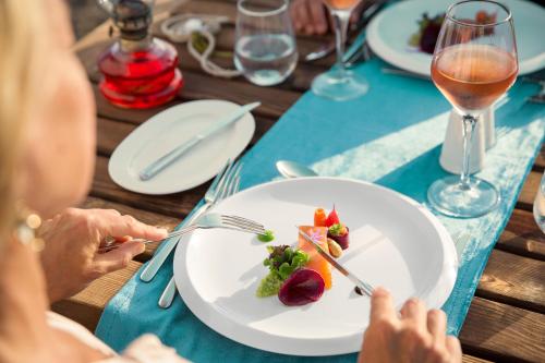 a woman sitting at a table with a plate of food at ROBINSON SARIGERME PARK - All Inclusive in Dalaman