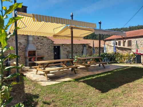 two picnic tables under a pavilion in a yard at Ribança Village in Destriz