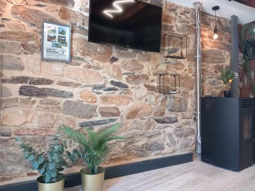 a stone wall with a flat screen tv on it at Ribança Village in Destriz