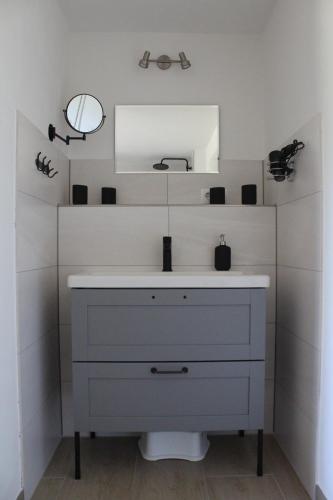 a bathroom with a white dresser and a mirror at Ferienwohnung Feldblick in Struppen