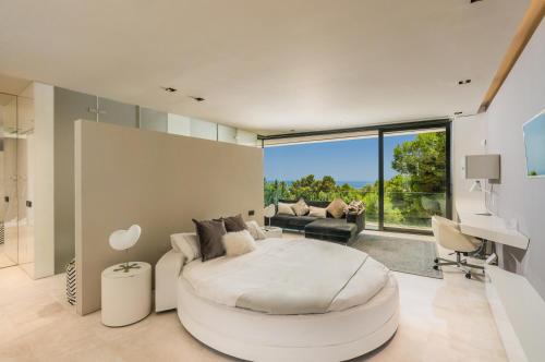 1 dormitorio con 1 cama blanca grande y escritorio en Buccara Villa El Nido, en Marbella