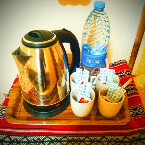 a tea kettle and some cups on a wooden tray at Majido Hotel in Wadi Musa