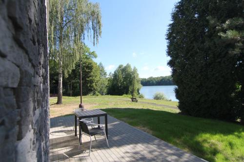 a bench sitting on a brick walkway next to a lake at Trdlovy Apartmány a Chata Tatranec v areálu Jaškovské krčmy in Horní Těrlicko