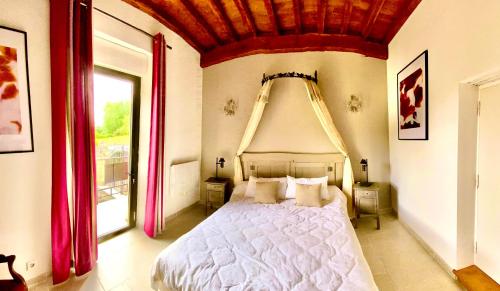 a bedroom with a large bed with a red ceiling at Domaine des Mauves in Berbiguières