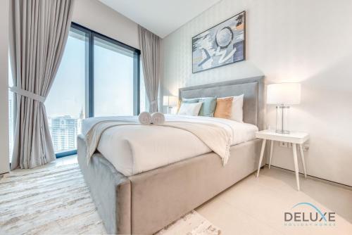 ein Schlafzimmer mit einem Bett und einem großen Fenster in der Unterkunft Remarkable 1BR at The Address Residences in JBR by Deluxe Holiday Homes in Dubai