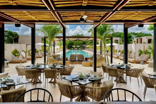 an outdoor dining area with tables and chairs and a pool at Hacienda Xcanatun, Angsana Heritage Collection in Mérida