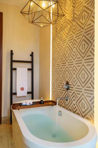 a bath tub in a bathroom with a wall at Hacienda Xcanatun, Angsana Heritage Collection in Mérida