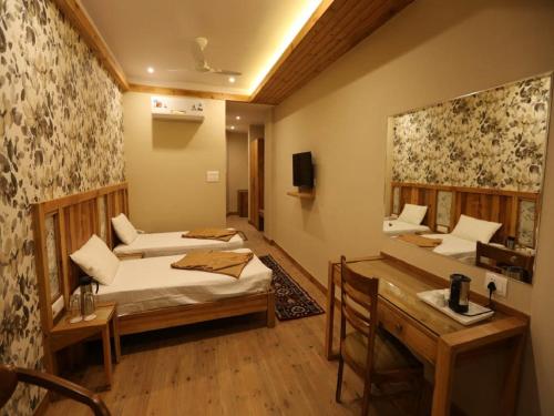 a room with two beds and a desk in it at D's Casa - A Unique Spanish Boutique House in McLeod Ganj