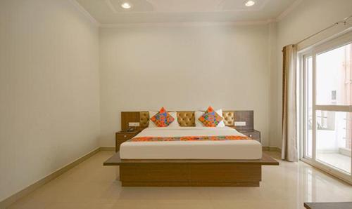 a bedroom with a large bed and a large window at FabHotel Yamunotri Retreat, Tapovan in Rishīkesh