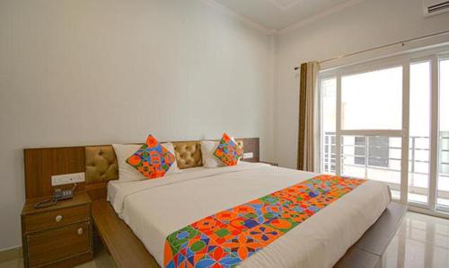 ein Schlafzimmer mit einem großen Bett und einem Fenster in der Unterkunft FabHotel Yamunotri Retreat, Tapovan in Rishikesh